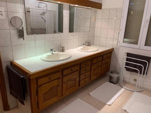 a bathroom with two sinks and a mirror at Appartement Salvaterra in Sauveterre