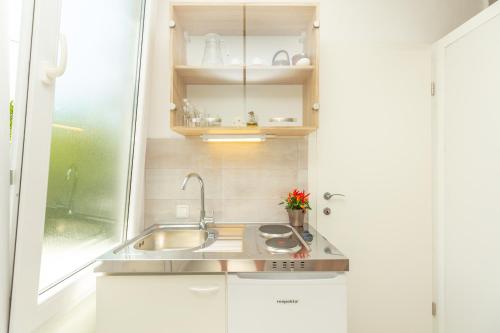 eine kleine Küche mit einem Waschbecken und einem Fenster in der Unterkunft Studio Amy in Dubrovnik