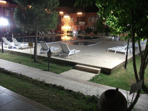 a group of chairs sitting around a pool at night at Samdan Hotel in Pamukkale