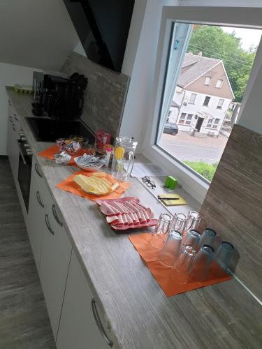 una encimera de cocina con comida y vasos. en ANJA'S motel, en Bruchmühlbach-Miesau