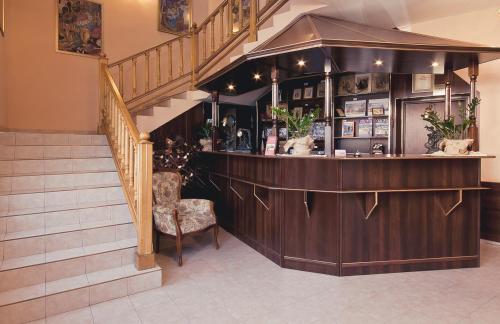 a bar in a building with a staircase and a chair at Hotel TERESITA in Krakow