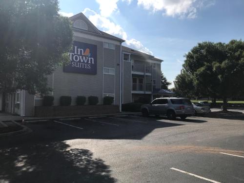 a building with a car parked in a parking lot at InTown Suites Extended Stay Columbia SC - Broad River in Columbia