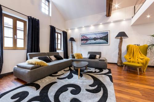a living room with two couches and a rug at Les suites sainte claire in Annecy