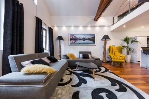 a living room with two couches and a rug at Les suites sainte claire in Annecy