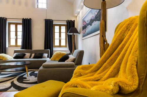 a living room with a yellow blanket on a couch at Les suites sainte claire in Annecy