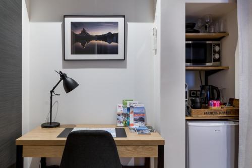 a home office with a desk and a picture on the wall at Les suites sainte claire in Annecy