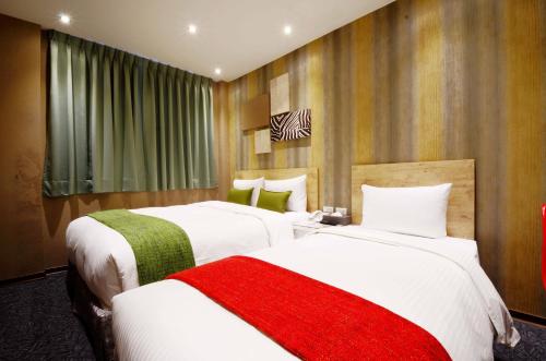 two beds in a hotel room with white and red blankets at ARK Hotel - Dongmen in Taipei