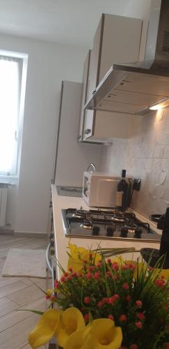 a kitchen with a stove with flowers on the floor at Karina House-check in H 24 in Como