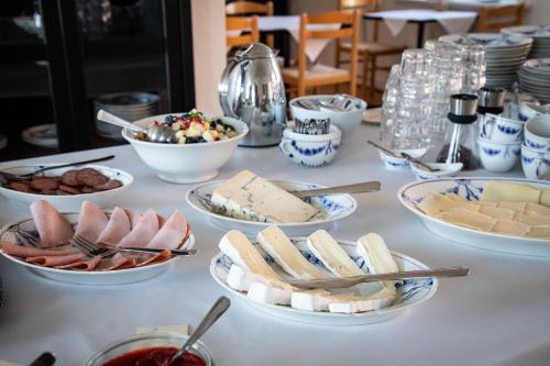 a table topped with plates of cheese and other foods at Pension Holmegaard in Sandvig
