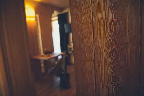 a room with a wooden door and a room with a desk at Alpen Hotel Chalet in Valdidentro