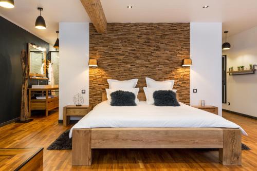 um quarto com uma parede de tijolos e uma cama grande em Les suites sainte claire em Annecy