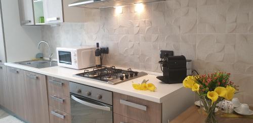 una cucina con piano cottura e forno a microonde bianco di Karina House-check in H 24 a Como
