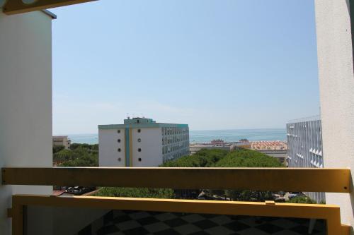 a wooden bench sitting on a balcony with buildings at FLATS SOLARIUM in Bibione