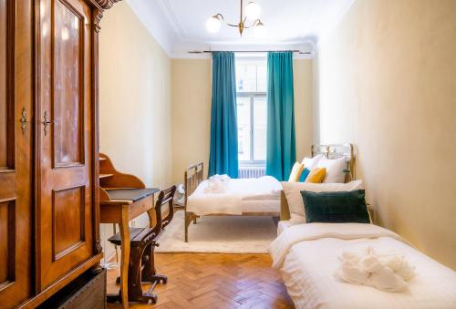 sypialnia z 2 łóżkami, biurkiem i oknem w obiekcie Luxurious Kafka family apt in Old Town w Pradze
