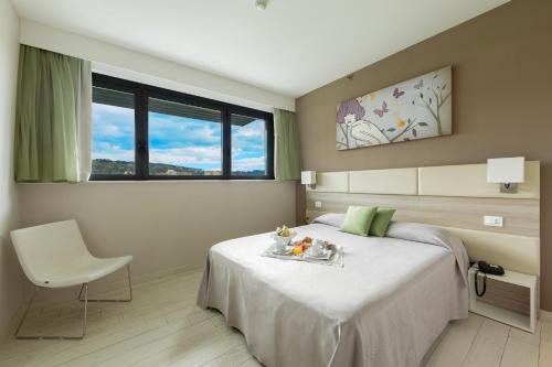 a bedroom with a bed and a chair and a window at Hotel Cristina in Naples