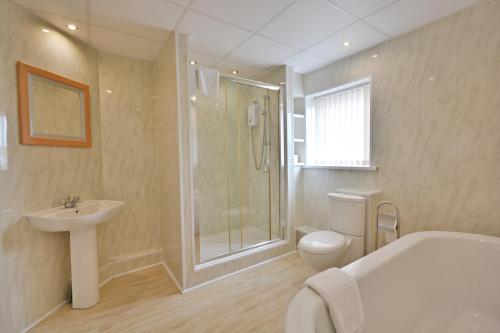 e bagno con doccia, servizi igienici e lavandino. di Stuart hotel a Blackpool