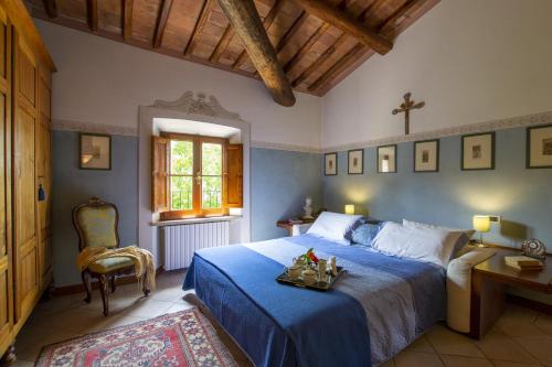ein Schlafzimmer mit einem blauen Bett und einem Stuhl in der Unterkunft Villa Mocarello in Poggibonsi