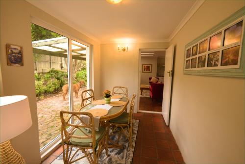 a dining room with a table and chairs and a dog at Kairos Lodge in Hout Bay