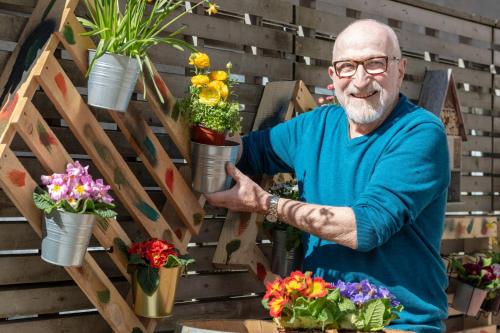 an older man holding flower pots in a flower shop at Blue City Boutique Hotel in Baden