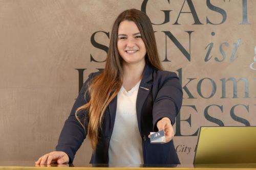 a woman sitting at a table in front of a laptop at Blue City Boutique Hotel in Baden