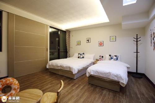 a bedroom with two beds and a table and chairs at 93 街房 近溪頭 杉林溪 紫南宮 國旅卡商店 in Zhushan