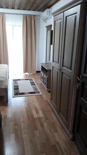 a bedroom with a door and a bed and a rug at Mateo Transalpina in Săsciori
