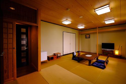 a living room with a table and a tv at Good Stay Mizuho in Usa