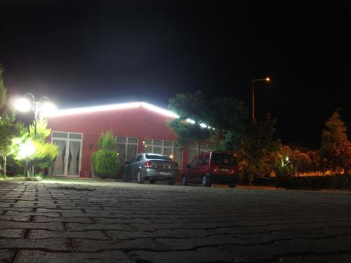 a red building with two cars parked outside at night at Samdan Hotel in Pamukkale