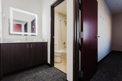 a bathroom with a sink and a toilet and a mirror at Palacio Royale Inn Boutique Katy in Katy