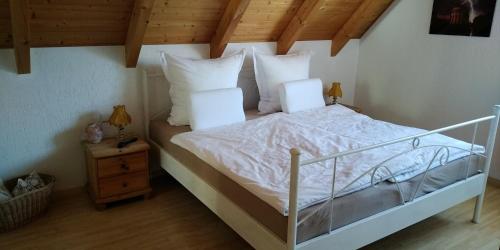1 dormitorio con 1 cama con sábanas y almohadas blancas en Ferienwohnungen am historischen Ludwigskanal, en Kelheim