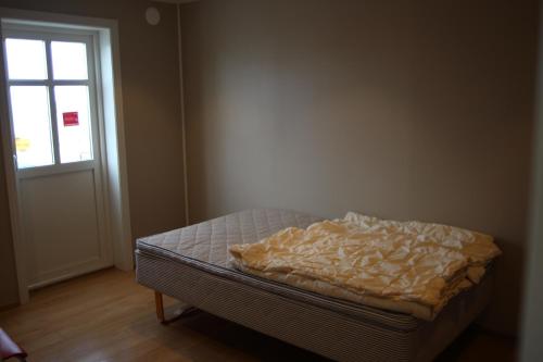 uma cama não feita num quarto com uma janela em Kobbaneset HK - Tett på havet - Bekkjarvik em Bekkjarvik