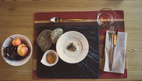 a table with a plate of food and a bowl of fruit at Alpen Hotel Chalet in Valdidentro