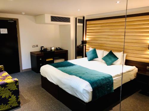 Schlafzimmer mit einem großen Bett mit einem Kopfteil aus Holz in der Unterkunft Maitrise Hotel Maida Vale - London in London