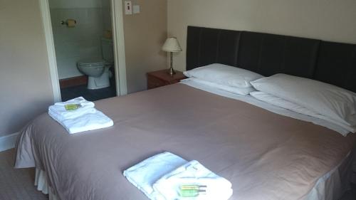 a bedroom with a large white bed with towels on it at The New Swan Hotel in Swansea