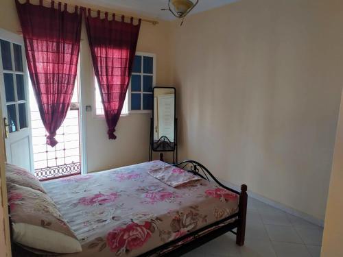 a bedroom with a bed with pink curtains and a window at Dar Pikhasa in Saidia 