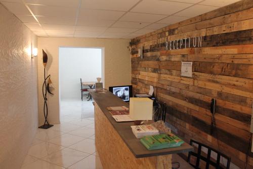 oficina con pared de madera, escritorio y sillas en L'hôtel du Bastier, en Ginasservis