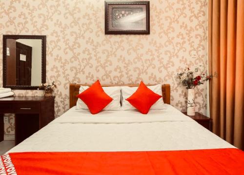 a bedroom with a bed with red pillows and a mirror at Nh&agrave; Nghỉ Tr&agrave; My in Như Thức
