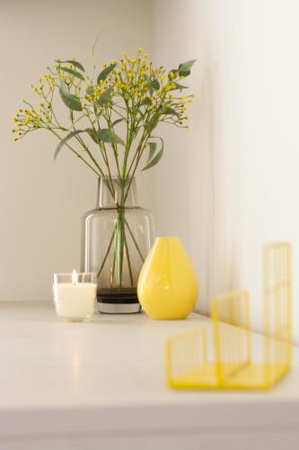 a vase with flowers and a yellow container on a table at Luxury Summer House in La Spezia