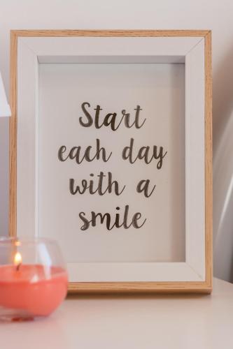 a picture of a candle and a picture of start each day with a smile at Luxury Summer House in La Spezia