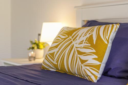 a yellow and white pillow sitting on top of a bed at Luxury Summer House in La Spezia