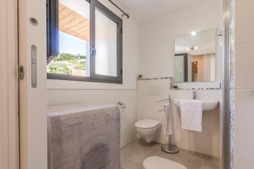 a bathroom with a toilet and a sink and a window at Luxury Summer House in La Spezia