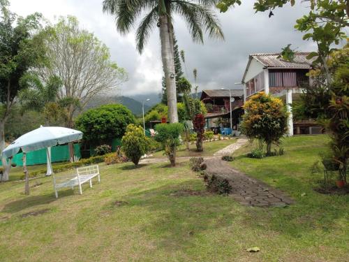 a park with a white bench and a house at Villa Kyra in Calima