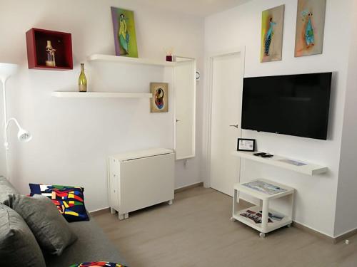 a living room with a couch and a flat screen tv at Apartamentos Playa Benitez in Ceuta