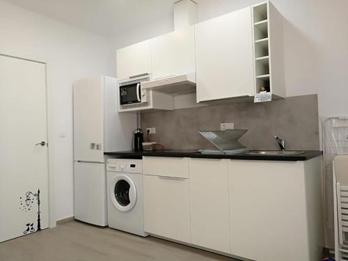 a white kitchen with a washing machine and a washer at Apartamentos Playa Benitez in Ceuta