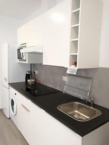 a kitchen with a sink and a microwave at Apartamentos Playa Benitez in Ceuta