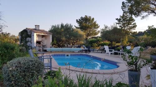 une piscine dans une cour avec une maison dans l'établissement Villa Valdor- Studio, à Cotignac