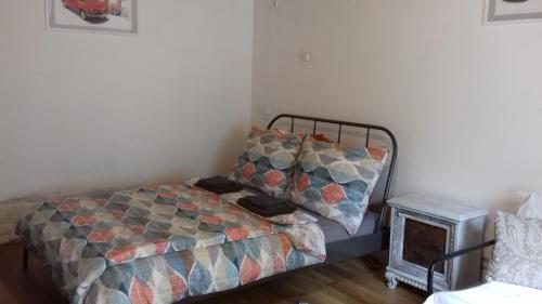 ein kleines Schlafzimmer mit einem Bett und einem Nachttisch in der Unterkunft Ov152 Apartman in Budapest