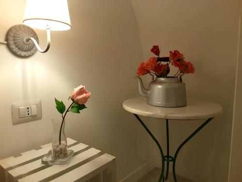 a table with a lamp and flowers in a room at SASSO BIANCO in Matera