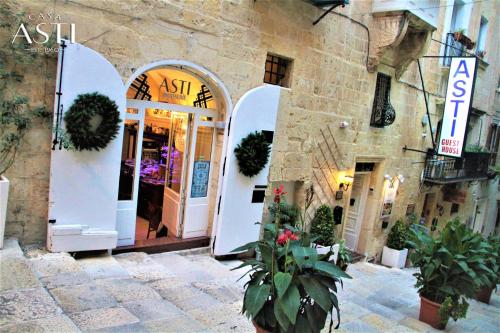 een toegang tot een gebouw met witte deuren en planten bij Casa Asti in Valletta