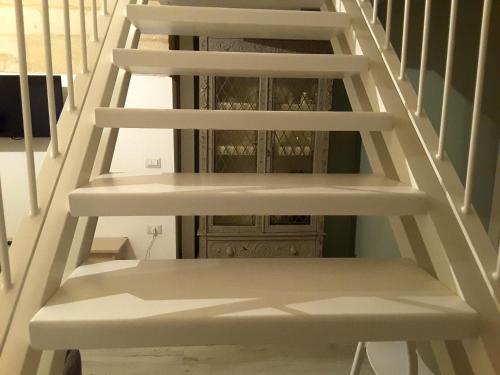 a staircase with white shelves and a wooden cabinet at SASSO BIANCO in Matera